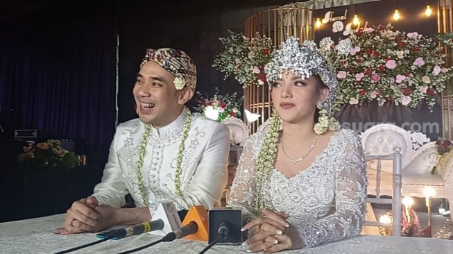 Ikmal Tobing dan Indah Lolita Bahar usai menikah di Hotel Sultan, Jakarta Pusat, Sabtu (25/6/2022) [Sheralot.com/Rena Pangesti]