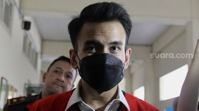 Terdakwa kasus pelanggaran Undang-Undang (UU) ITE Adam Deni berjalan menuju ruang sidang di Pengadilan Negeri Jakarta Pusat, Selasa (7/6/2022). [Sheralot.com/Angga Budhiyanto]