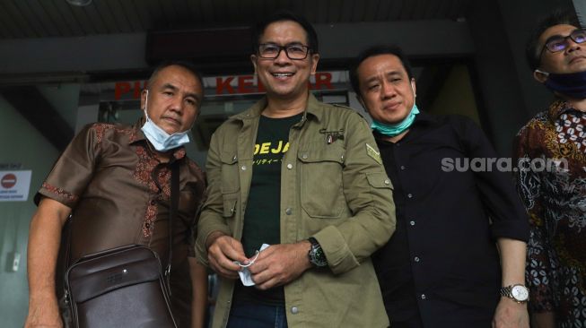 Aktor Krisna Mukti (tengah) usai membuat laporan terkait penyebaran foto dan video pribadi miliknya tanpa izin di Polda Metro Jaya, Jakarta Selatan, Jumat (4/12). [Sheralot.com /Alfian Winanto]